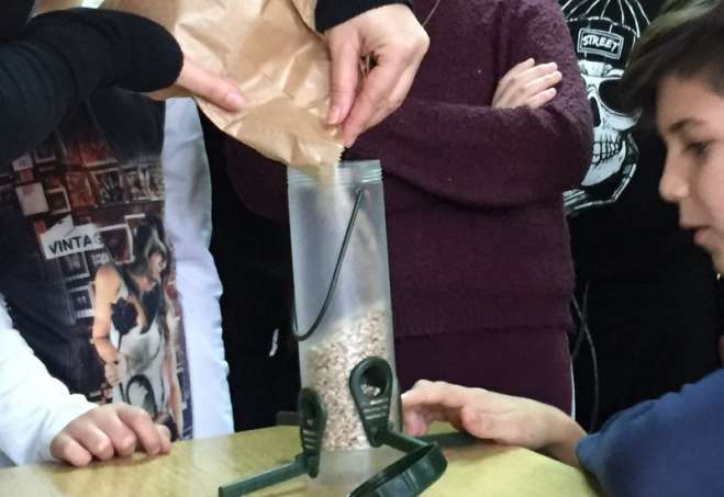 Punjenje hranilica hranom za ptice